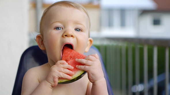Baby Eating A Watermelon On The Balcony