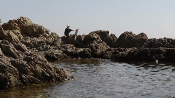 A Middle-aged Artist Makes a Picture of The Sea alt