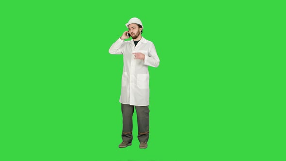 Engineer Talking on the Phone on a Construction Site on a Green Screen, Chroma Key