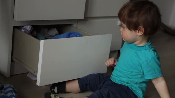 Little boy make a mess wit clothes in home. Candid view, Stock Footage