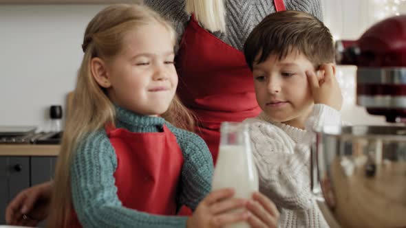 Video of little girl pouring milk into  electric mixer bowl. Shot with RED helium camera in 8K. alt
