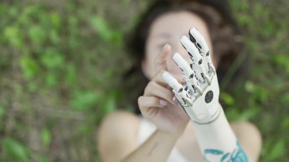 Girl is walking and resting in park Bionics Cybernetic Robotic-arm Hand prosthesis alt
