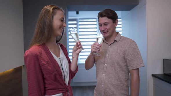 Medium Shot Husband and Wife Clinking Glasses Drinking Tasty Champagne Moving in New Apartment alt