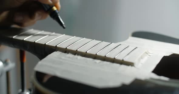 Luthier Marks Frets on the Guitar By Black Marker Before Sanding Musical Instruments Repair Shop 60p alt