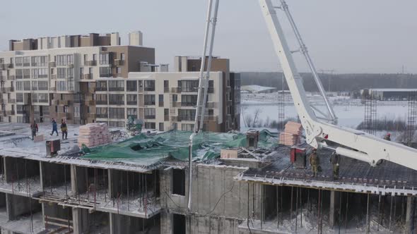 A Drone View of the Construction of a Residential Building Using a Concrete Pump alt