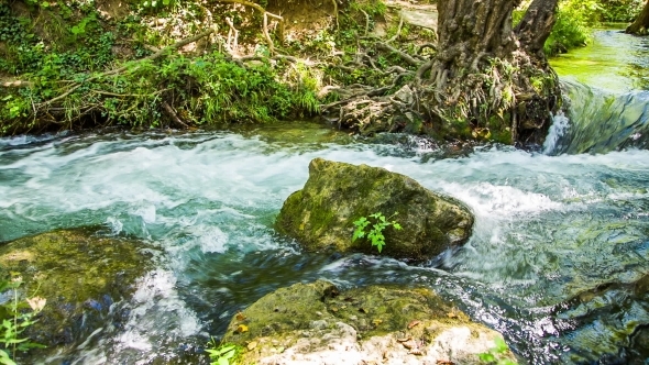 Rapid Mountain River Flowing Among Mossy Rocks And