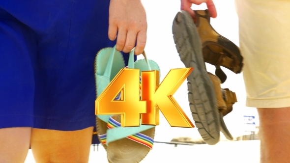Couple Walking On The Beach With Sandals In Hands alt