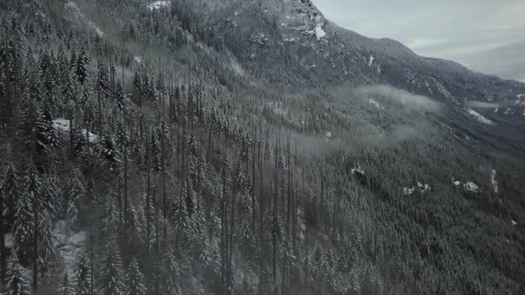 Wide aerial forward flygh shot of a frozen cloudy valley in Vancouver ...