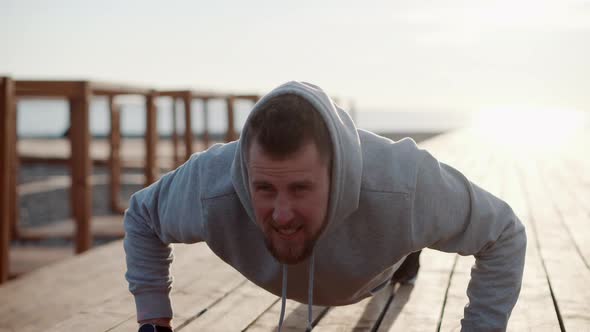 Strong Man Is Making Pushups Outdoors in Sunny Morning alt