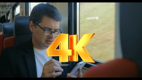 Young Man Using Cell To Browse Online In Train Young Man Using Cell To Browse Online In Train
