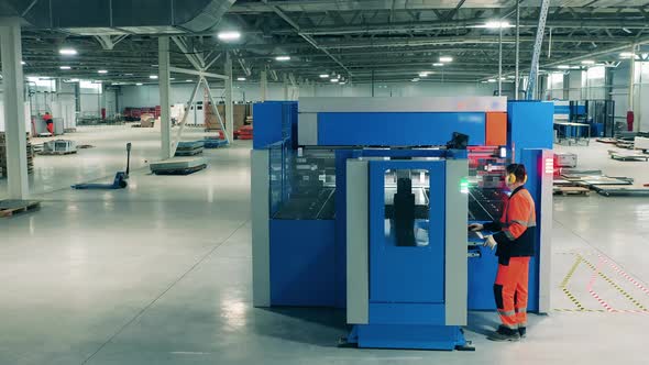 Laser Cutting Machine Is Being Managed By a Factory Employee alt