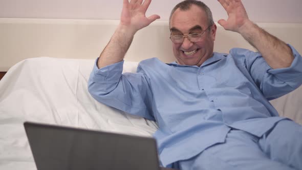 Reaction of Success By Happy Man Using Laptop in Bed alt