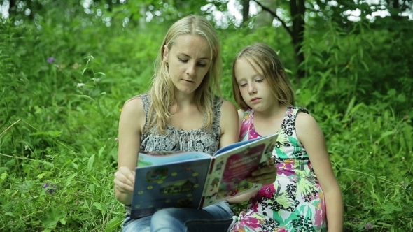 Mother Reading Book To Her Daughter In The Park Mother Reading Book To Her Daughter In The Park
