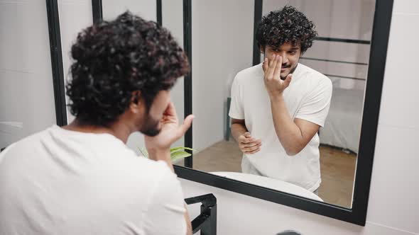 Asian Indian Man Enjoys Smearing Cream on Face in Bathroom alt