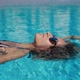 Close Up of an Young Woman is Enjoying and Having Relax in Outdoor Swimming Pool in a Luxury Hotel - VideoHive Item for Sale