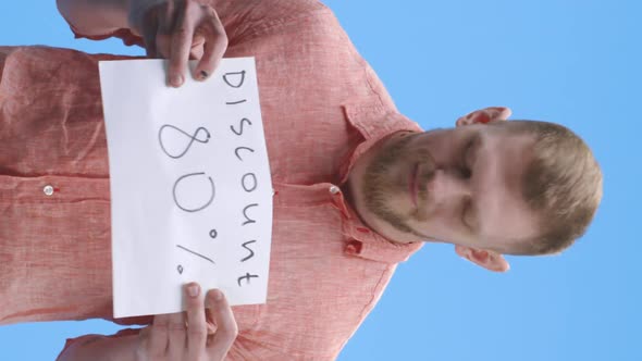 Young Man Holding Discount Sign alt