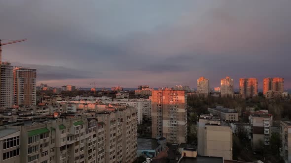 Purple Clouds in Grey Sky Over Cityscape in Golden Hour of Sunset