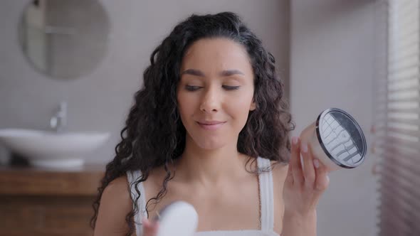 Closeup Young Attractive Hispanic Woman Standing in Bathroom Holding Jars in Hands Puzzled Girl in alt