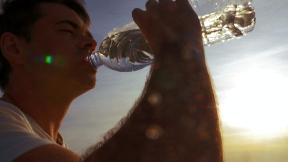 Young Man Drinking Water Outdoor At Sunset Young Man Drinking Water Outdoor At Sunset