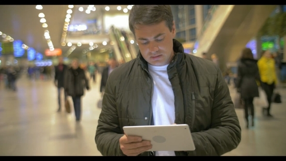 Man Using Digital Tablet In Airport Hall Man Using Digital Tablet In Airport Hall