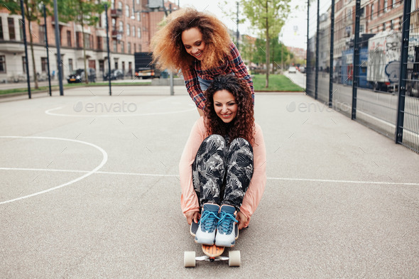 Young girls skating in basketball court - Stock Photo - Images
