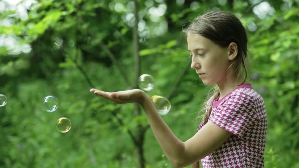 Young Girl Catches Soap Bubbles In The Park Young Girl Catches Soap Bubbles In The Park