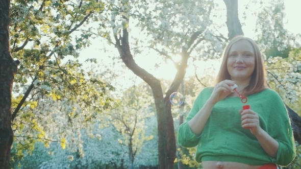 Happy Pregnant Woman Blowing Bubbles In Bloomy Happy Pregnant Woman Blowing Bubbles In Bloomy