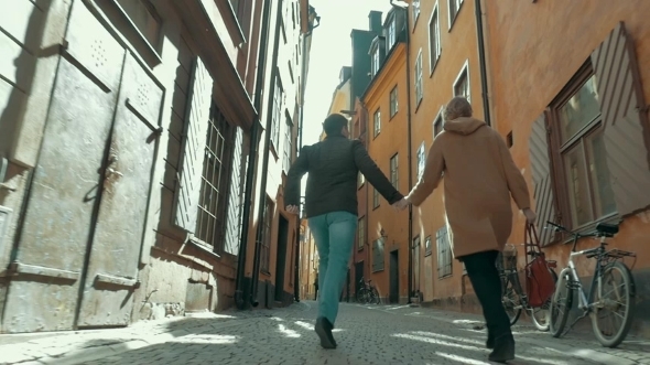 Happy Couple Running Along The Narrow Street Happy Couple Running Along The Narrow Street