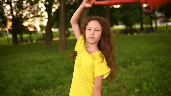 a Schoolgirl Girl with Curly Hair Rejoices at the Beginning of the Holidays and Throws Up a School alt