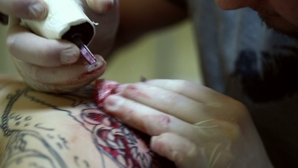 Master Draws Tattoo In Red Ink
