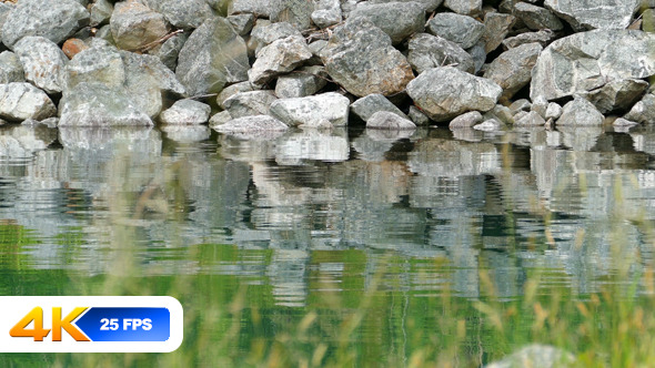 Rocks on the Shore of a Fjord Reflect in Water Rocks on the Shore of a Fjord Reflect in Water