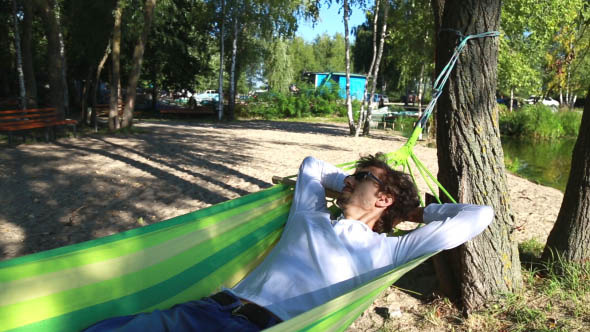 Man Rests in a Hammock on the Beach Man Rests in a Hammock on the Beach