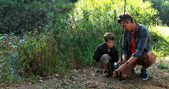 Father teaching son to use fishing rod in the park alt