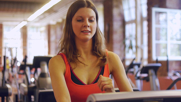 Attractive Young Woman Runs On A Treadmill