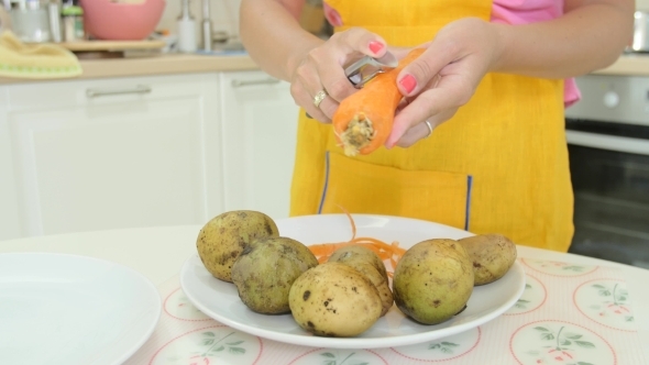 A Woman With Orange Manicure Peeling a Carrot A Woman With Orange Manicure Peeling a Carrot