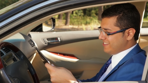 Businessman Sitting In The Car Reading Tablet Businessman Sitting In The Car Reading Tablet