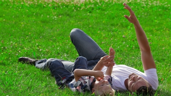 Father And Son Dreaming On The Grass In Park Father And Son Dreaming On The Grass In Park