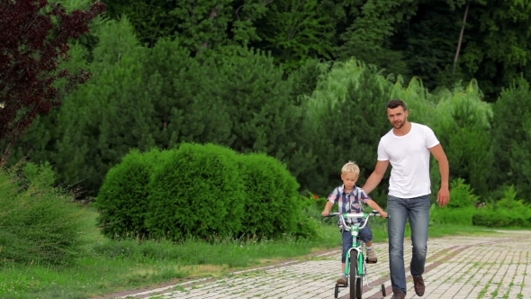 Father Teaching His Son To Ride a Bike Father Teaching His Son To Ride a Bike