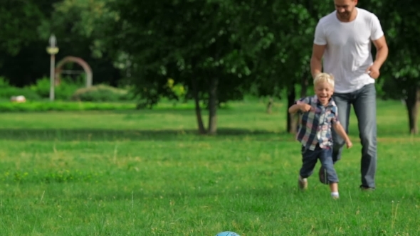 Father And Son Playing Ball In The Park Father And Son Playing Ball In The Park