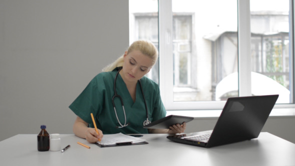 Lady Doctor Working in Clinic with Tablet Lady Doctor Working in Clinic with Tablet