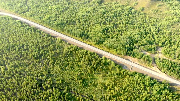 Aerial Flying Over an Empty Rural Road Without a Car Between Forests