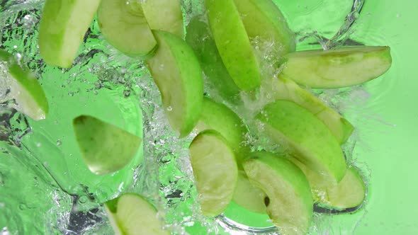 Super Slow Motion Shot of Green Apple Cuts Falling and Splashing Into Water at 1000Fps alt