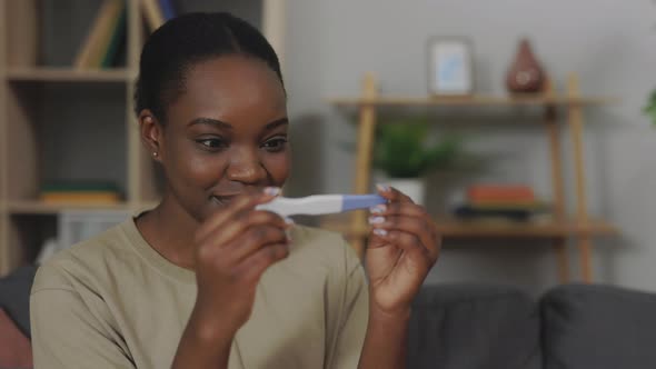 Happy Woman Getting Two Stripes on Pregnancy Test at Home alt