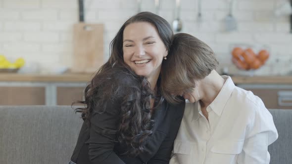 Two Happy Young Caucasian Women Laughing Sitting on Couch at Home alt