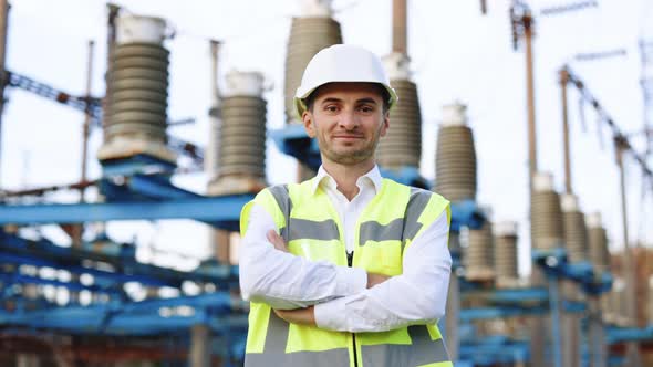 Portrait of Happy Male Engineer in Protective Helmet Crossing Arms While Looking to Camera