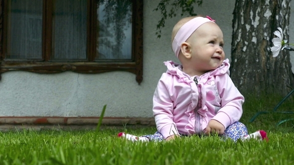 Seven Month Baby Plays On a Lawn