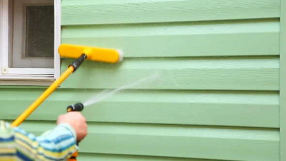 Human Hand Spraying And Washing House Wall