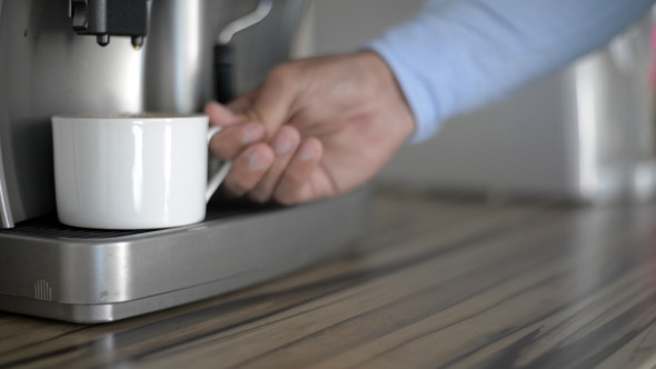 Taking Full Cup of Coffee from Coffee Maker Taking Full Cup of Coffee from Coffee Maker
