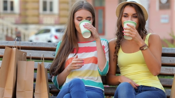 Two Girls On a Bench Drinking Coffee Two Girls On a Bench Drinking Coffee