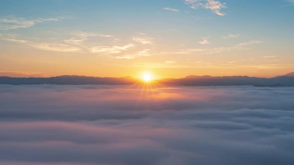 4K Timelapse of beautiful sunrise with fog rolling over mountain in Thailand alt
